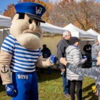 Louie the Laker giving a kid a fist bump.